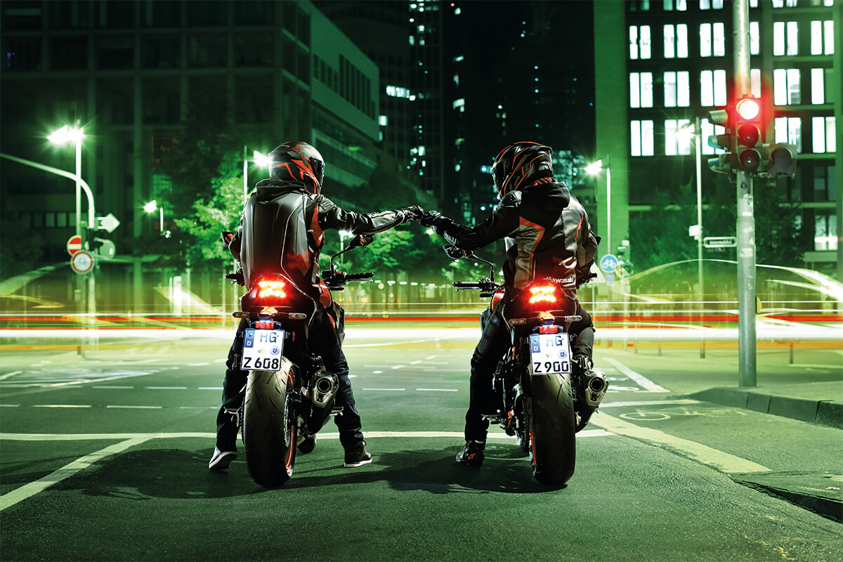 Rear angle of two riders on motorcycles on a city street.