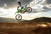 Three-quarter front angle of a person making a jump on their motorcycle off-road.