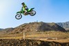 Side angle of a person making a jump on their motorcycle off-road.