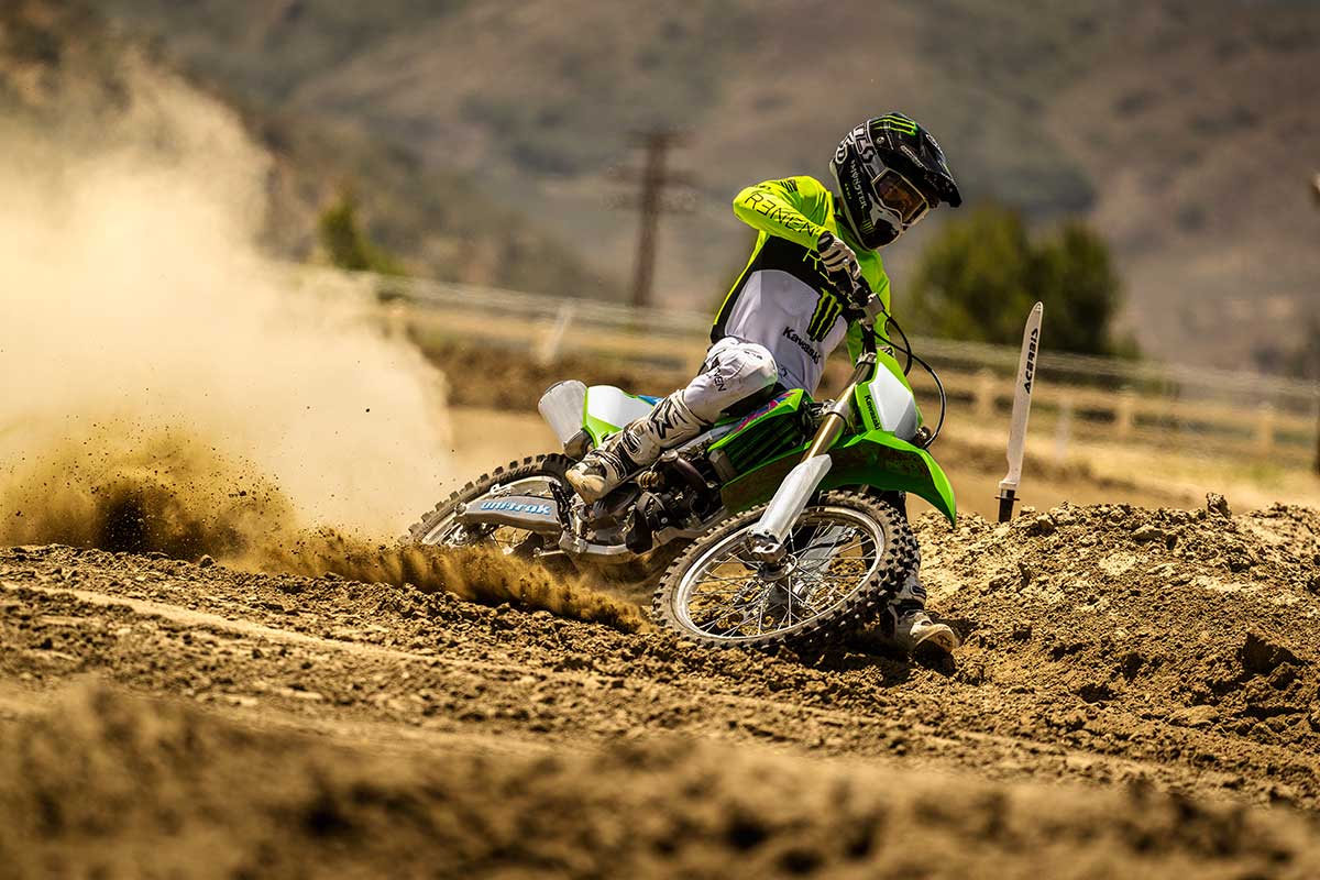 Three-quarter front angle of a person riding a motorcycle off-road.