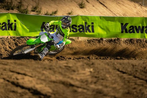 Three-quarter front angle of a person making a sharp turn on a motorcycle off-road. opens in a new window