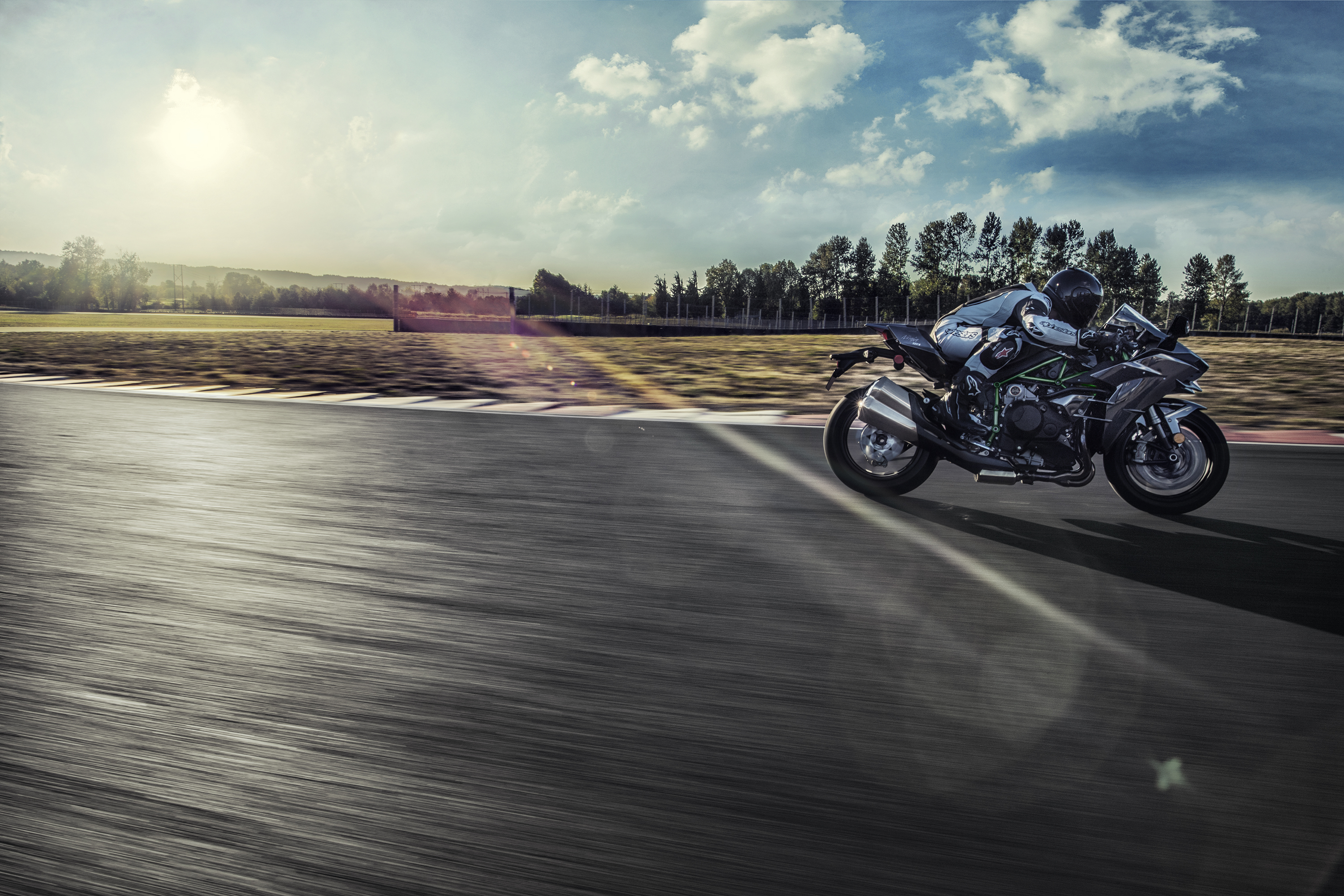 Side angle of a person riding a motorcycle on a racetrack.