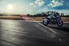 Side angle of a person riding a motorcycle on a racetrack.