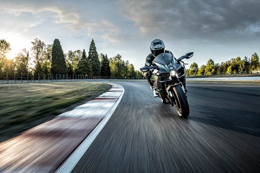 Front angle of a person riding a motorcycle on a track. opens in a new window