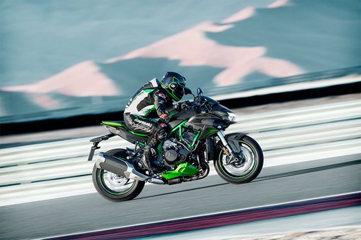 Side angle of a person riding a motorcycle on a racetrack. opens in a new window