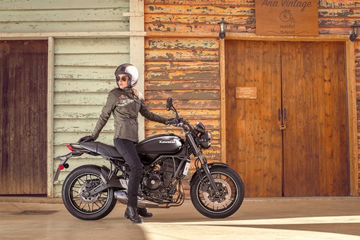 Profile angle of a person on a parked motorcycle. opens in a new window
