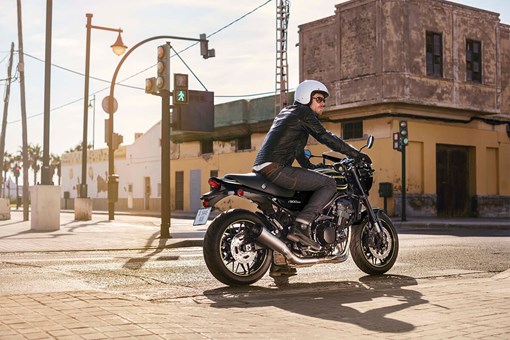 Side angle of a person on a motorcycle stopped at a red light. opens in a new window
