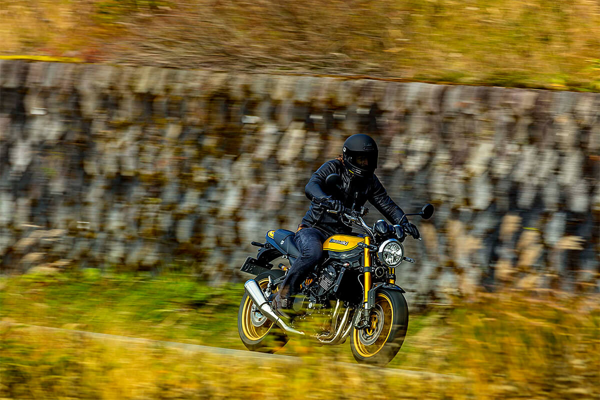 Three-quarter front angle of a person riding a motorcycle on a street.