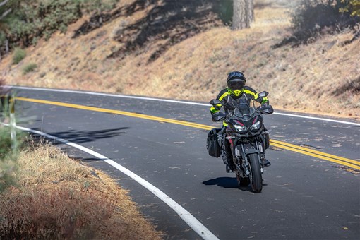 Front angle of a person riding a motorcycle on a road. opens in a new window