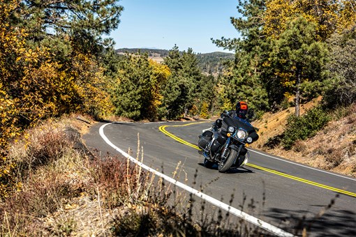 Front angle of a person riding a motorcycle on a road. opens in a new window