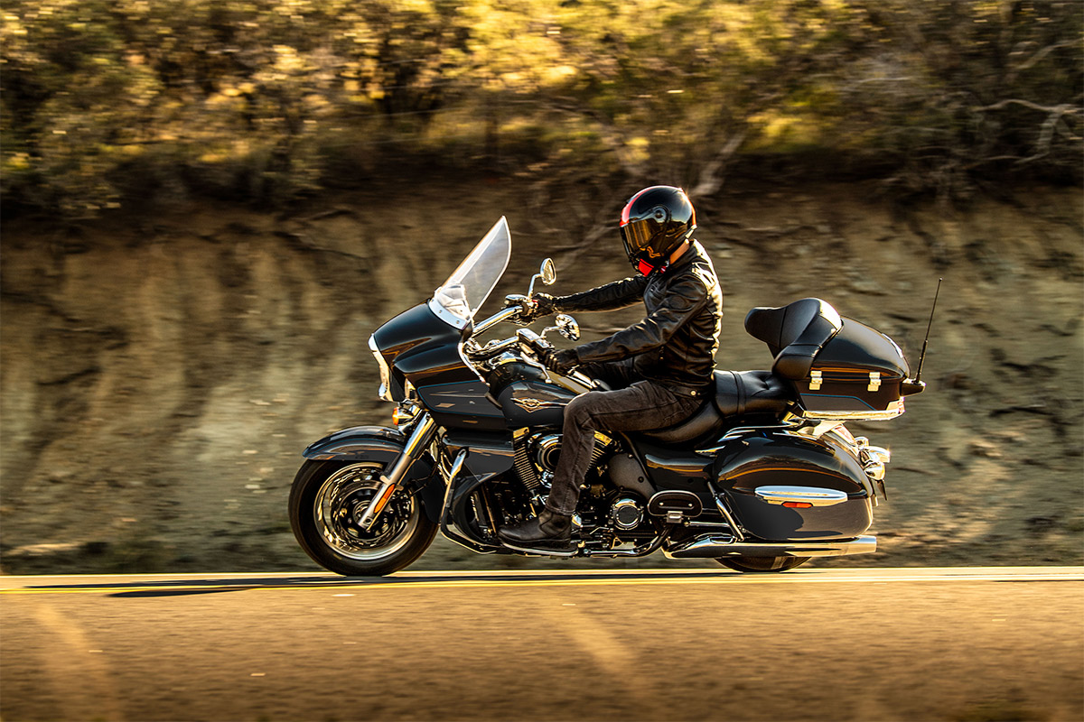 Profile angle of a person riding a motorcycle on a road.