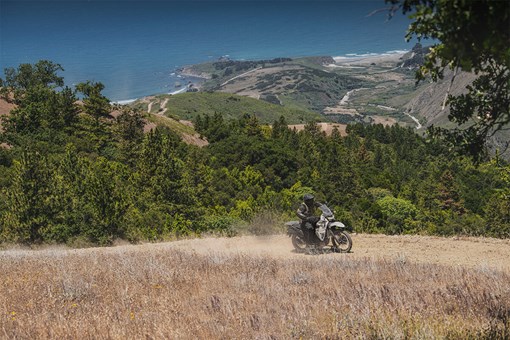 Profile angle of a person on a motorcycle on a dirt trail. opens in a new window