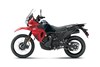 Profile angle of a red motorcycle staged in a white studio background.