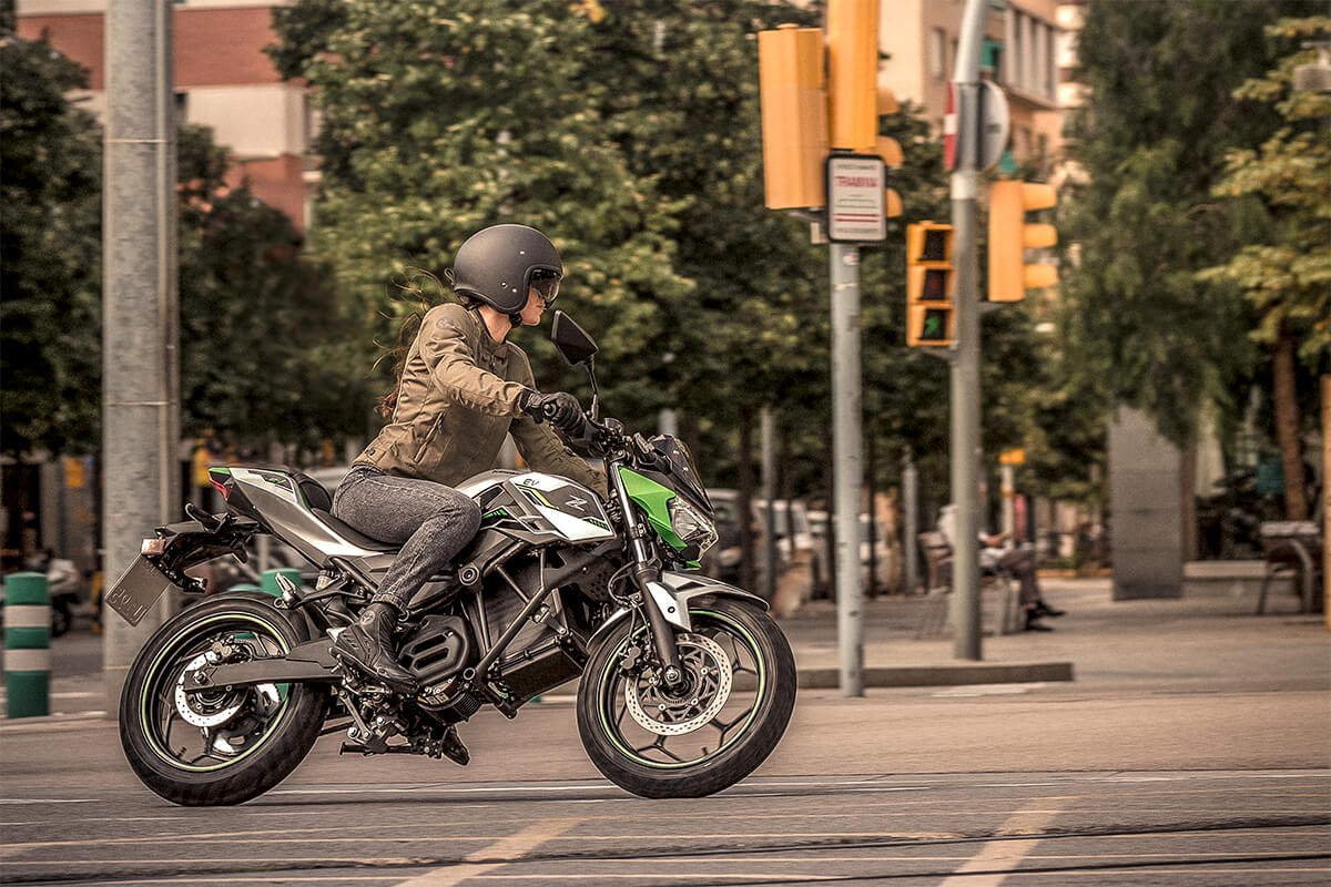 Profile angle of a person riding a motorcycle on a city street.