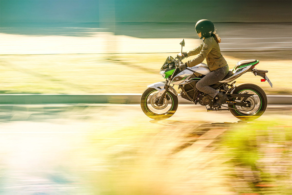 Profile angle of a person riding a motorcycle on a street.