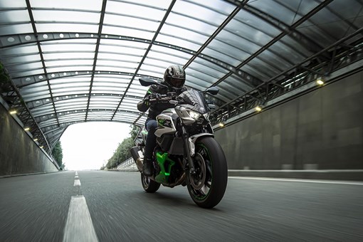 Front angle of a person riding a motorcycle on a street. opens in a new window