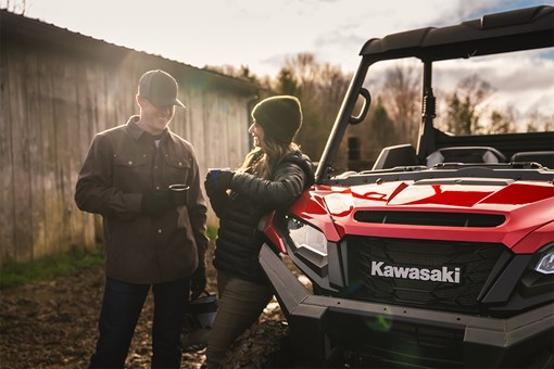 Front angle of a side x side parked near two people. opens in a new window