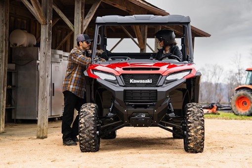 Front angle of a side x side parked next to a barn. opens in a new window
