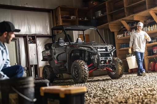Three-quarter front angle of a side x side parked in a garage. opens in a new window