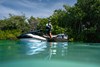 Side angle of a person standing on a personal watercraft.