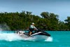 Profile angle of a person riding a personal watercraft in water.