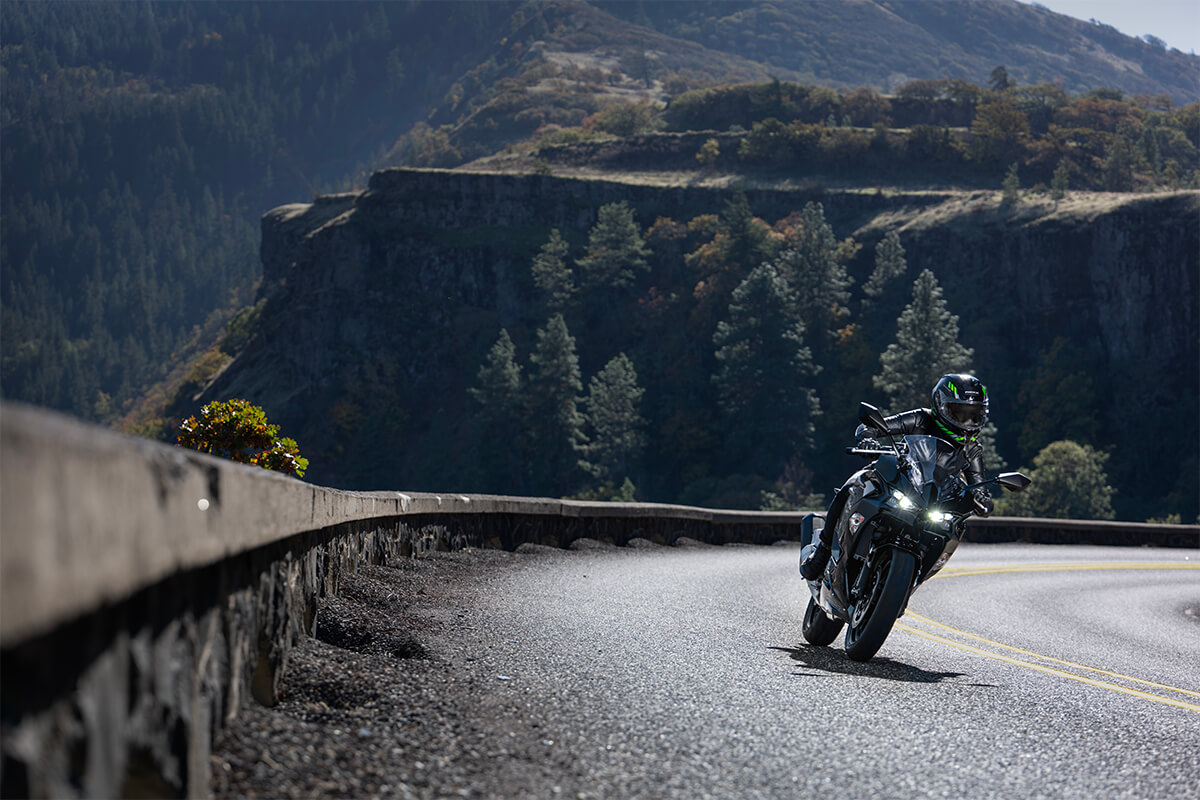 Front angle of a person riding a motorcycle on a winding road.