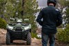 Front angle of a parked ATV with a person in the foreground.