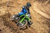 Three-quarter front angle of a person making a turn on a motorcycle off-road.