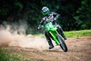 Front angle of a person riding a motorcycle on a dirt trail.