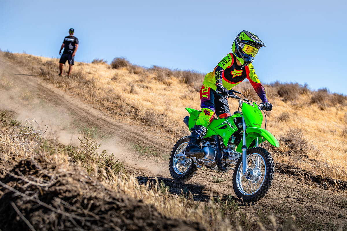 Three-quarter front angle of a person riding a motorcycle off-road.