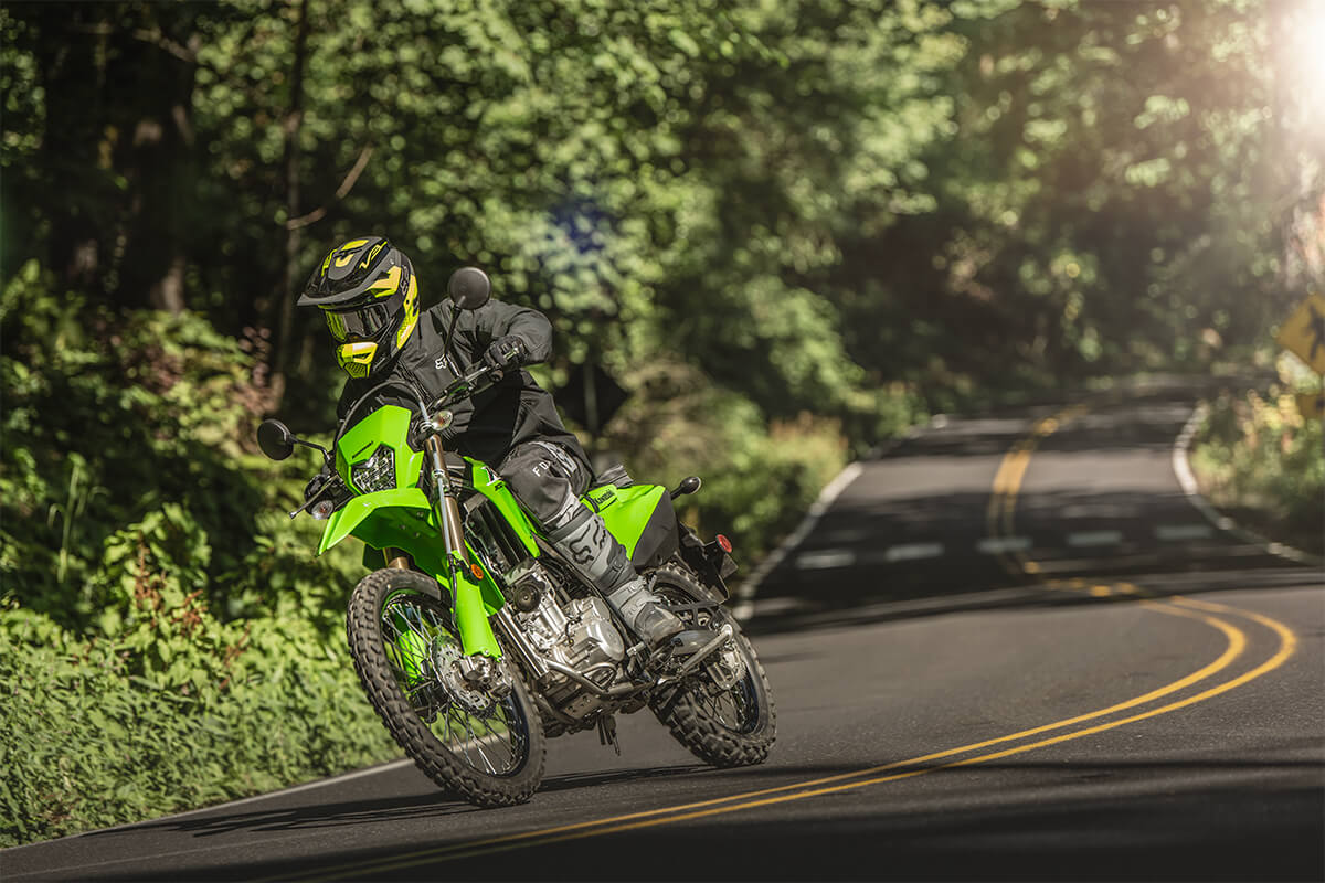Three-quarter front angle of a person riding a motorcycle on a highway.