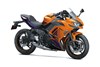 Three-quarter front angle of an orange and black motorcycle staged in a white studio background.