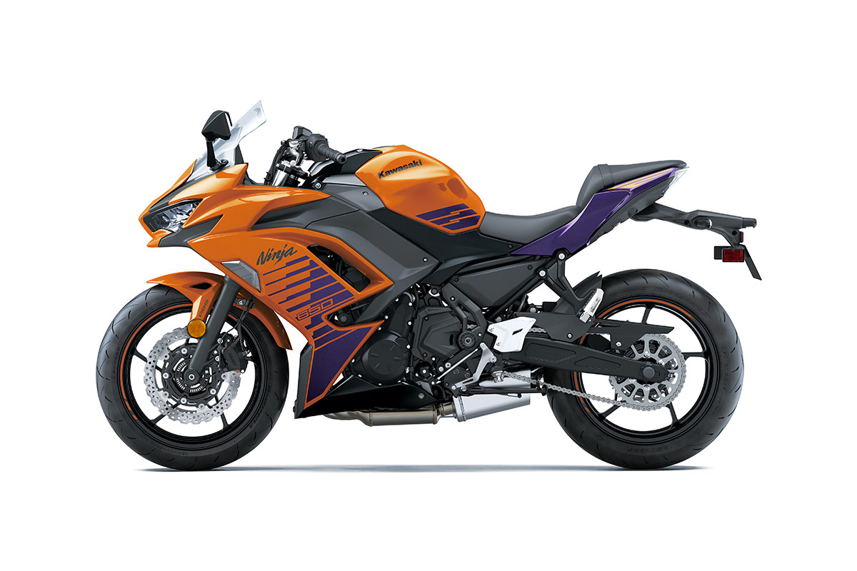 Side angle of an orange and black motorcycle staged in a white studio background.
