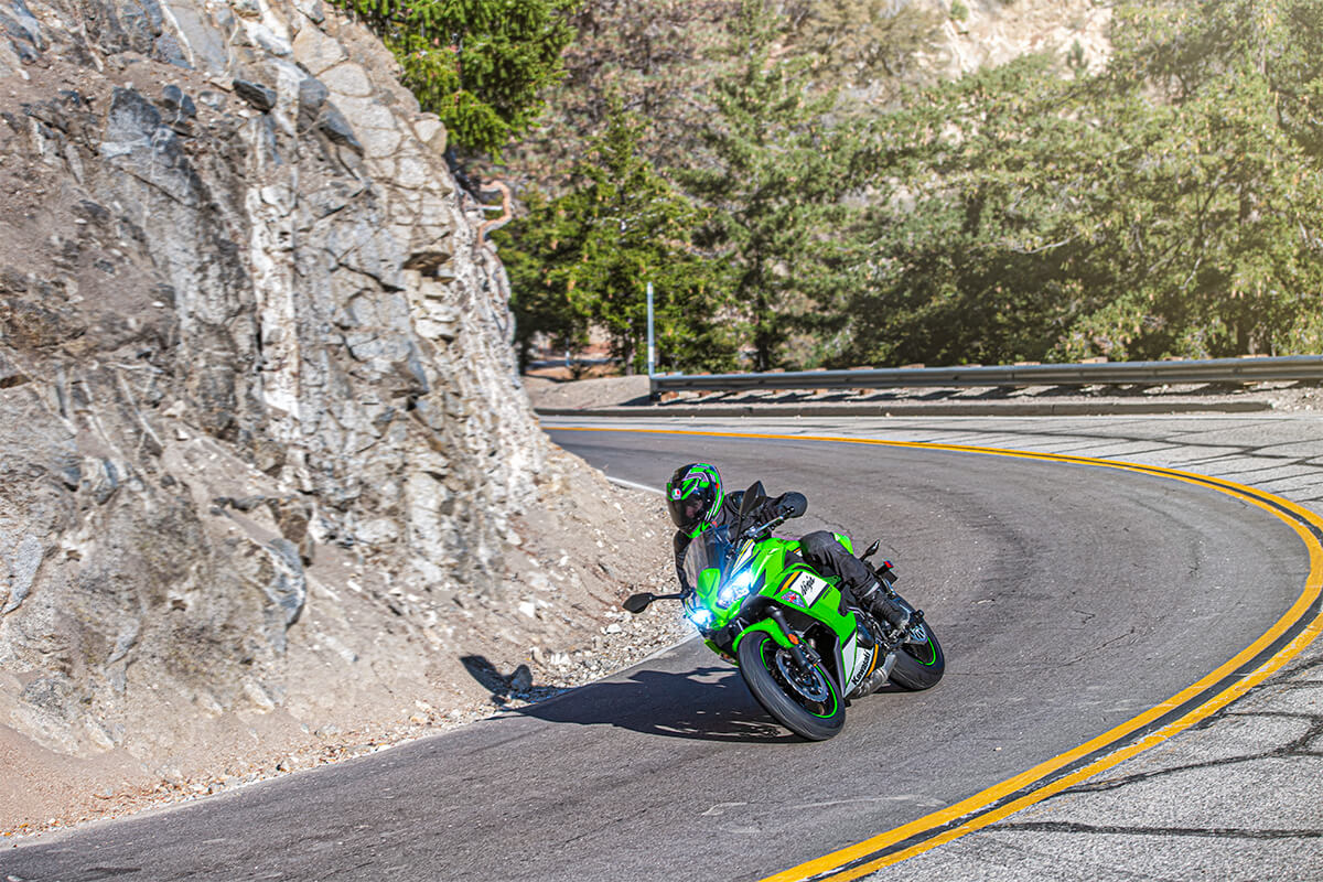Three-quarter front angle of a person riding a motorcycle on a highway.