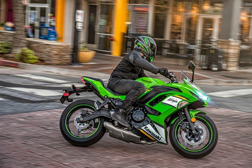 Side angle of a person riding a motorcycle in an urban city. opens in a new window
