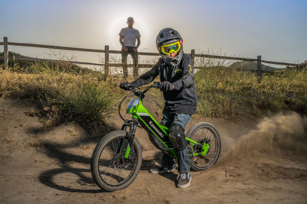 Side angle of a young adult sitting on an electric balance bike parked. 