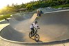 Overhead angle of a young adult riding an electric balance bike around a large turn.