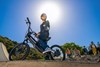 Ground level angle of a young adult sitting on an electric balance bike.