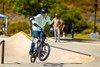 Three-quarter front angle of a young adult riding an electric balance bike in a skate park.