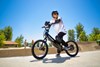 Three-quarter front angle of a young adult sitting on an electric balance bike.