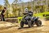 Three-quarter front angle of a person riding an ATV off-road.