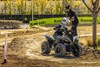 Three-quarter front angle of a person making a sharp turn on an ATV off-road.