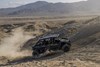 Profile view of a side x side driving off-road in the desert.