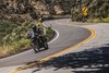 Three-quarter front angle of a person riding a motorcycle on a highway.