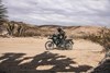 Side angle of a person riding a motorcycle off-road.