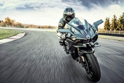 Front angle of a person riding a motorcycle on a racetrack. opens in a new window