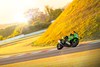 Side angle of a person turning a motorcycle on a racetrack.