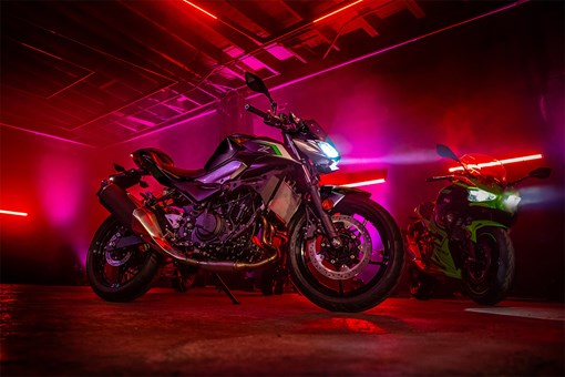 Side angle of a motorcycle staged in a warehouse with neon lights. opens in a new window