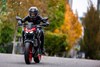 Front angle of a person riding a motorcycle on a city street.