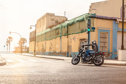  Side angle of a person riding a motorcycle on a rural street. opens in a new window